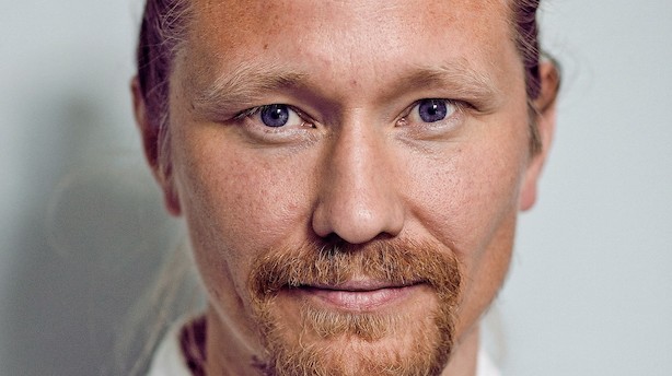 Modedirektør slapper af med en fodboldkamp i fjernsynet